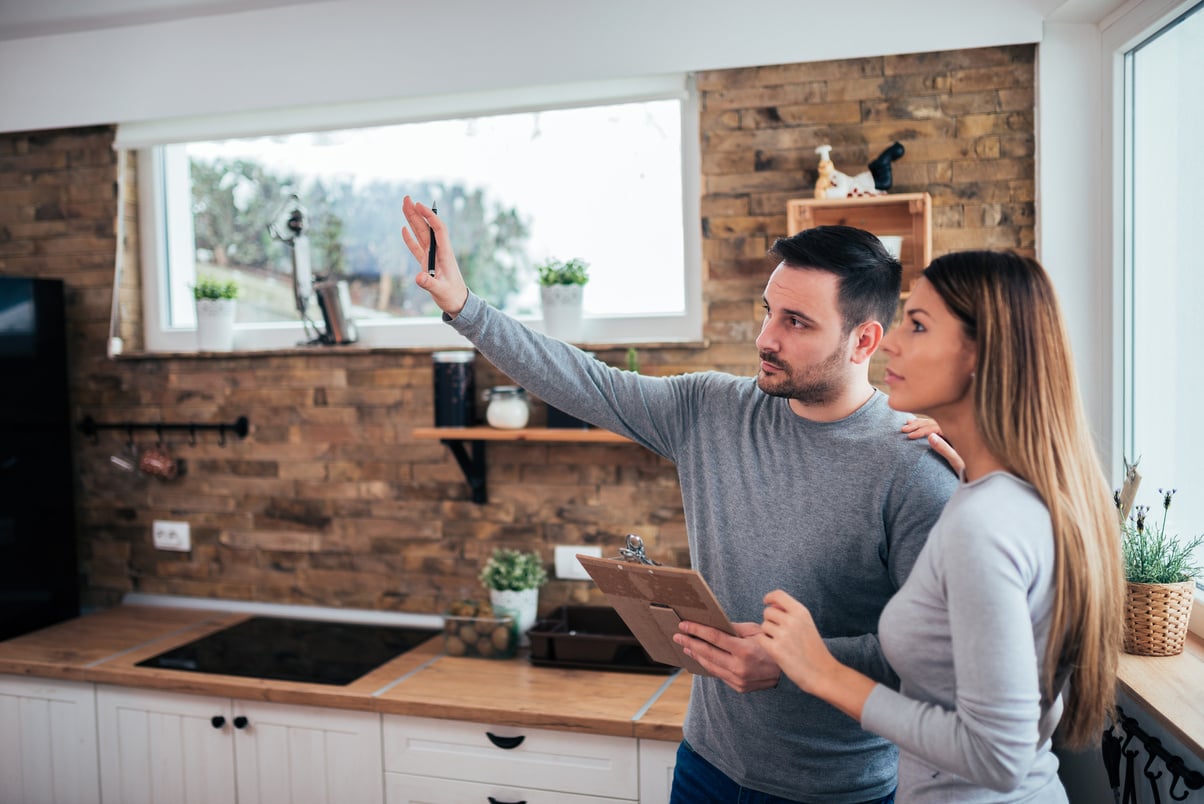 Couple talking about home renovation. Standing in the kitchen and discussing apartment renovation ideas.