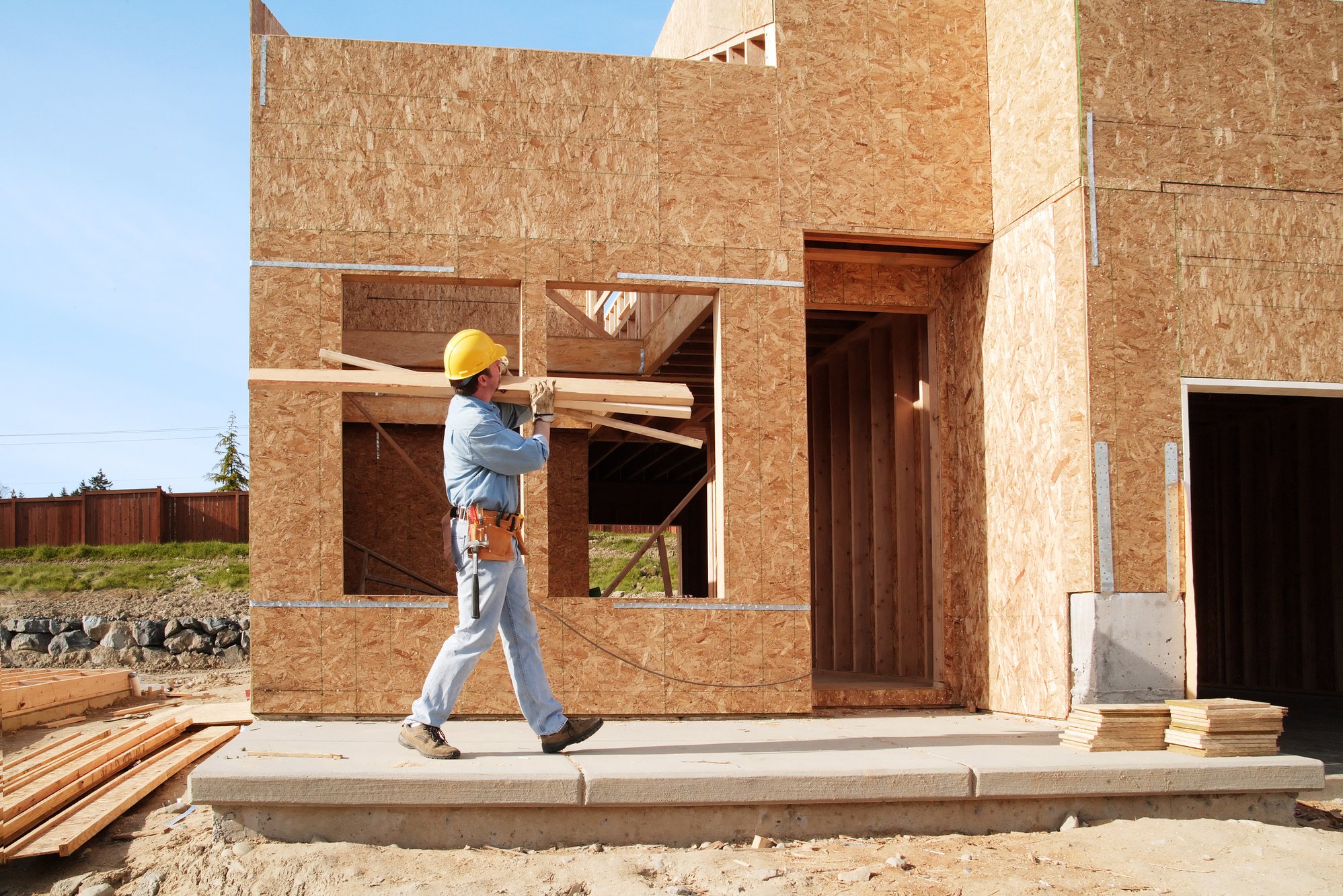 New home construction worker carring wood